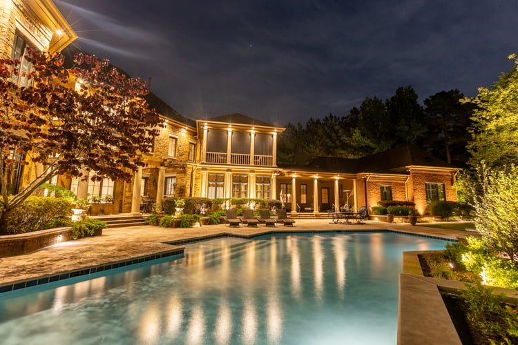 Backyard with pool and house with landscape lighting