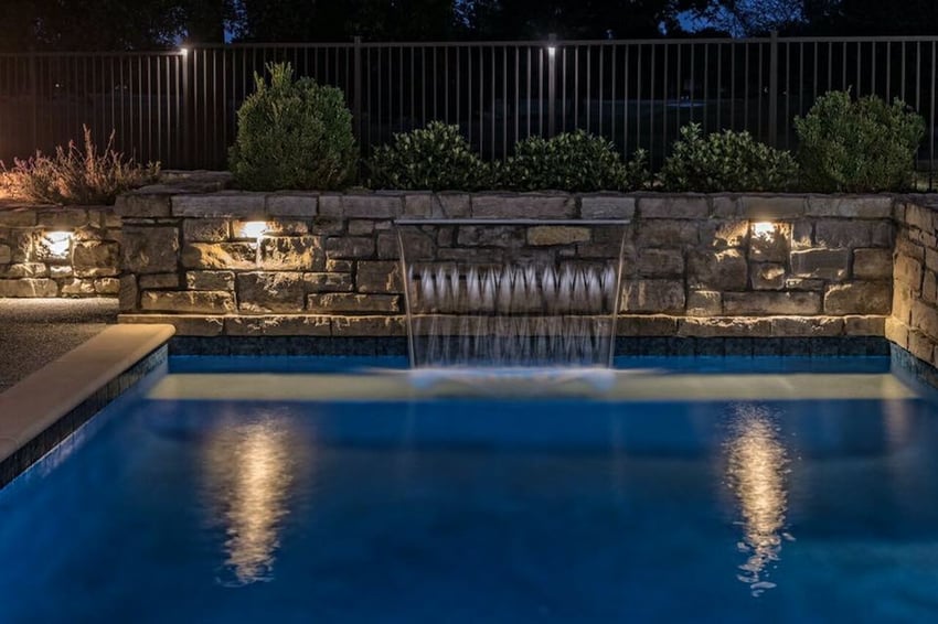 Pool lighting on fence and waterfall