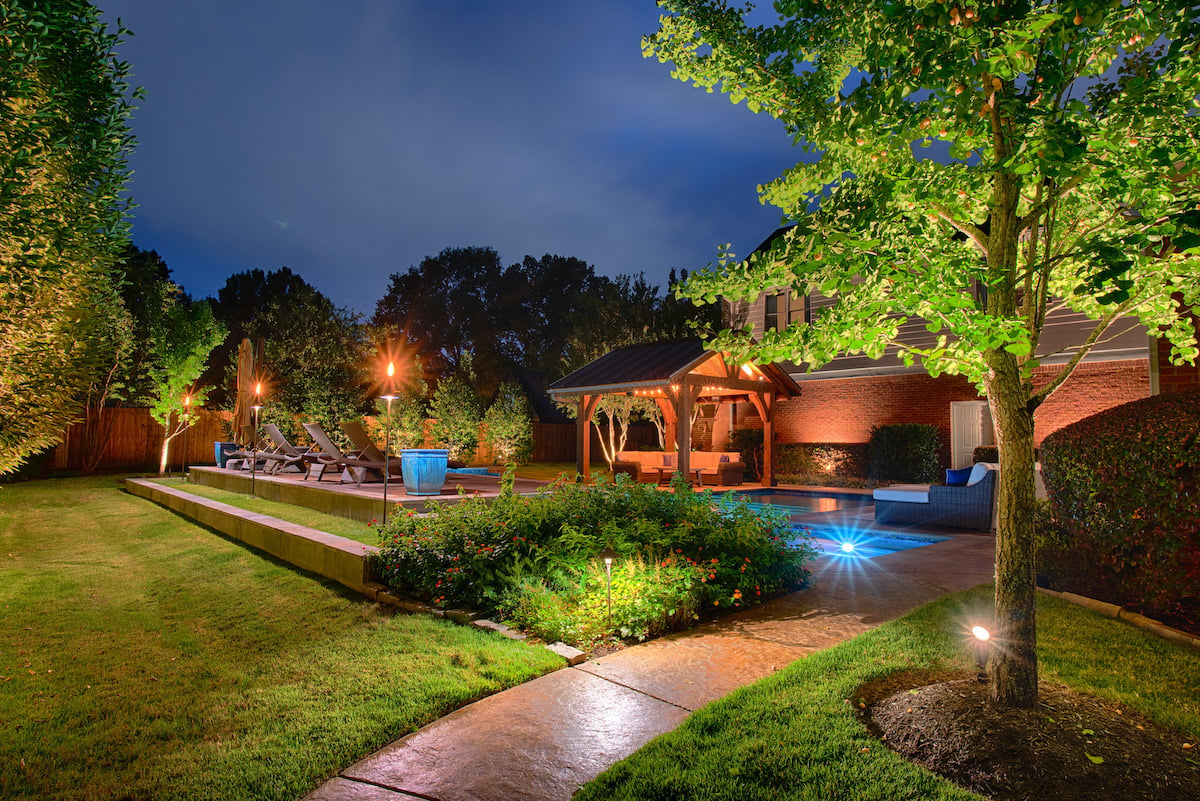 backyard with beautiful landscape lighting at night